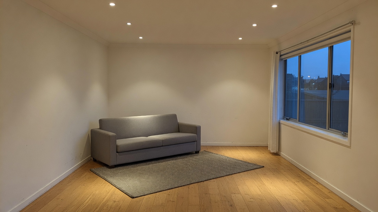 A generated placeholder image: an empty finished living room at dusk with six recessed downlights switched on and a window showing blue evening outside.